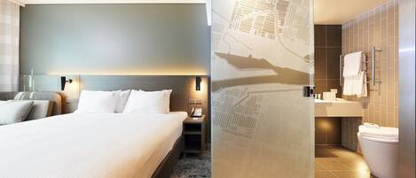 Ein Hotelzimmer mit Bett, Nachttisch und einem Badezimmer mit Toilette und Waschbecken.