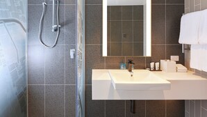 A modern bathroom with a shower, a large mirror, and a sink. - Holiday Inn Express Melbourne Southbank by IHG (Southbank)