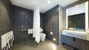 A modern bathroom with a shower, toilet, and sink.
