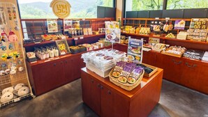 Un magasin où l’on trouve divers produits emballés, présentés sur des étagères et des comptoirs, notamment des en-cas et des produits alimentaires.