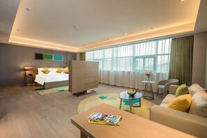 A modern hotel room with a bed, a sofa, a coffee table, and a small table with a vase of flowers. - The Mulian Hotel of Bantian Shenzhen (Shenzhen)