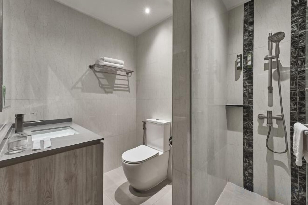 Une salle de bain moderne équipée de toilettes, d’un lavabo et d’une douche.