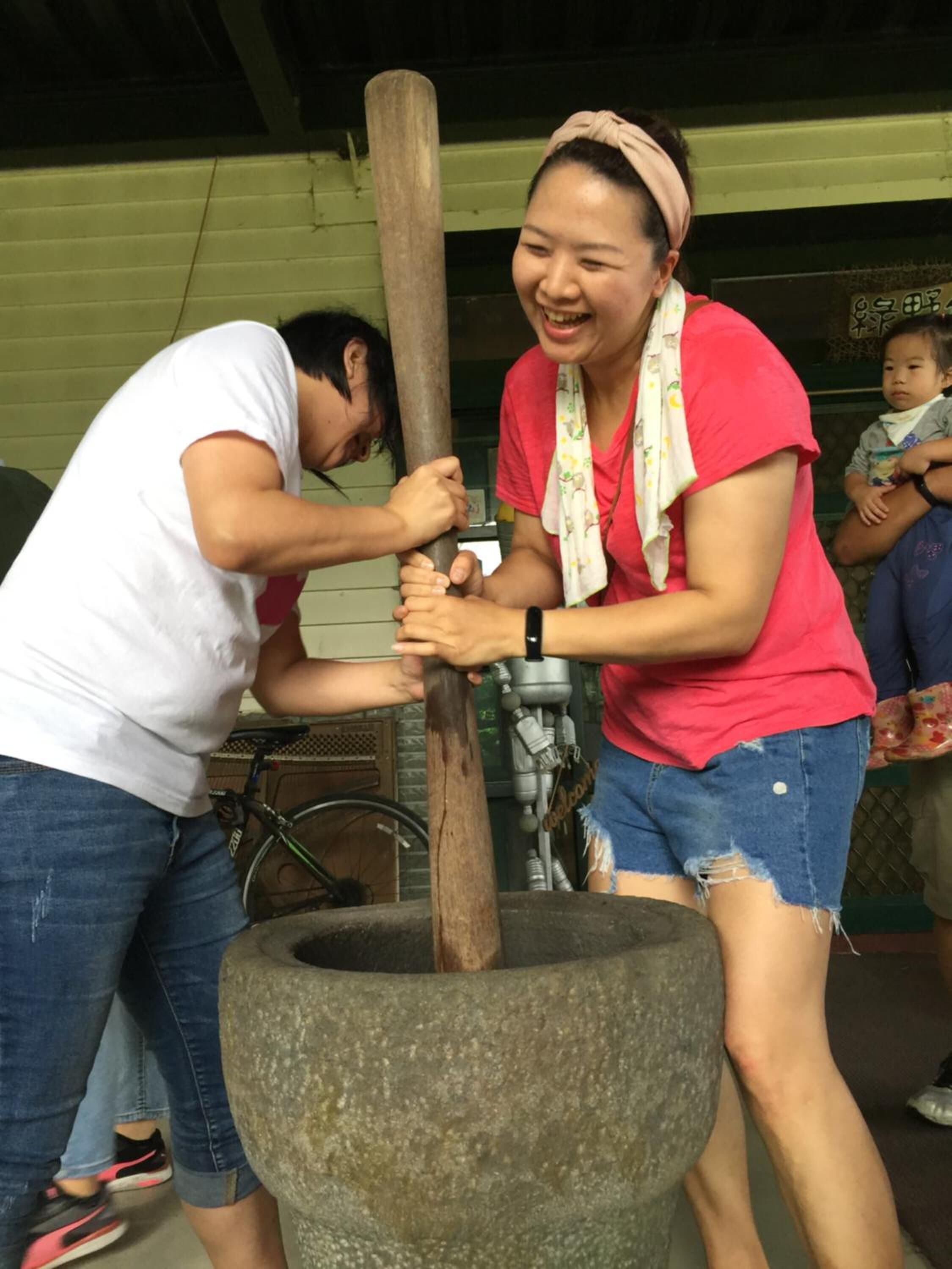 A person using a large stone mortar and pestle.