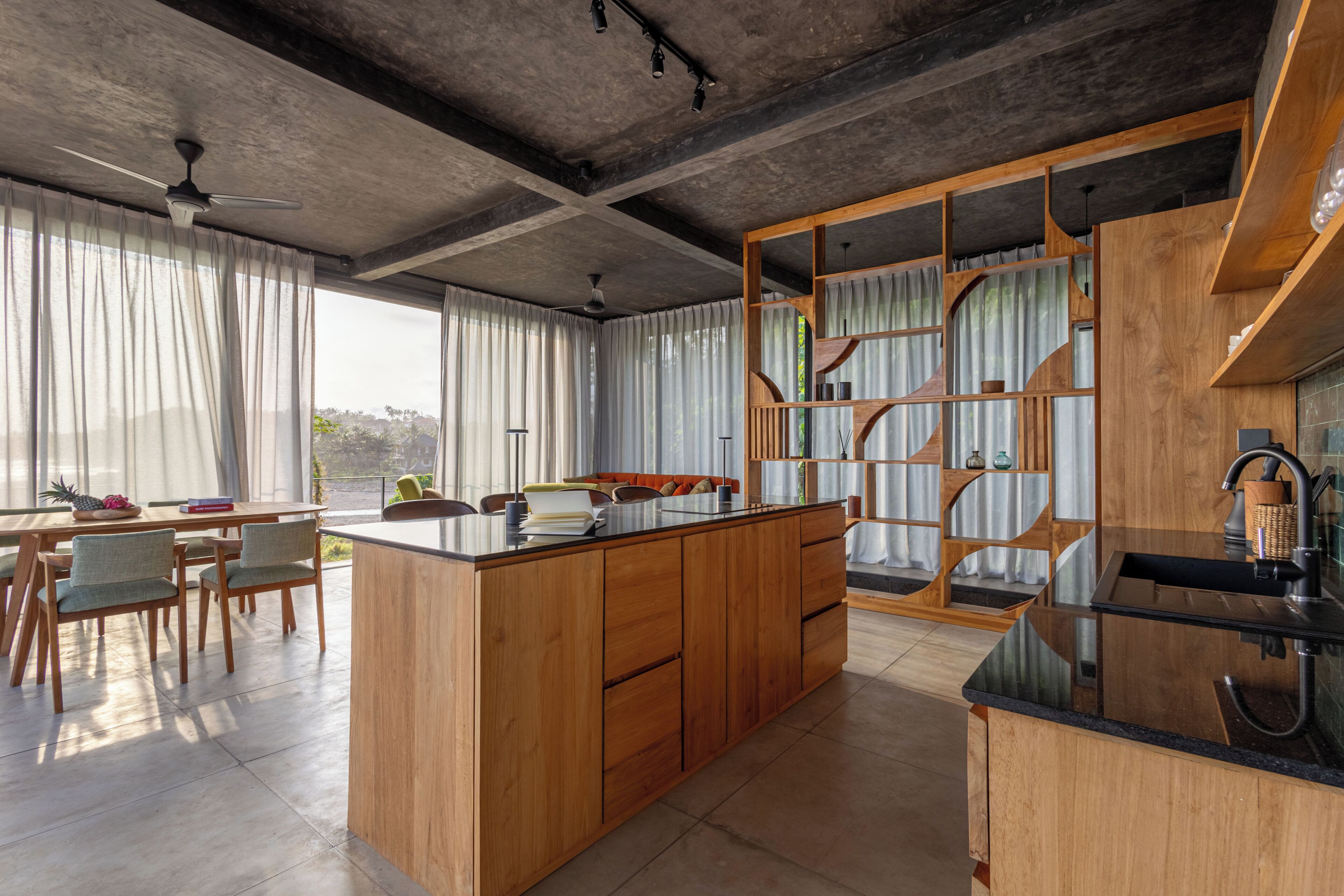 Cozinha moderna com ilha central, armários de madeira e pia embutida.