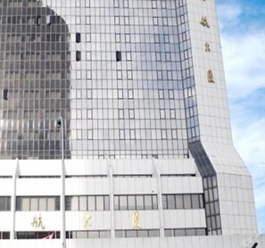 Ein modernes Gebäude mit einer rasterförmigen Fassade und einem markanten Eingang mit Beschilderung.