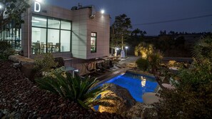 A modern building with a pool, outdoor seating, and a well-maintained garden. - Jeju 29 Pool Villa (Jeju City)