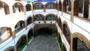 Pátio com várias arcadas e um espaço aberto central.