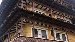 Um edifício de dois andares com telhado em telhas e varandas.