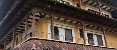 A two-story building with a tiled roof and balconies.
