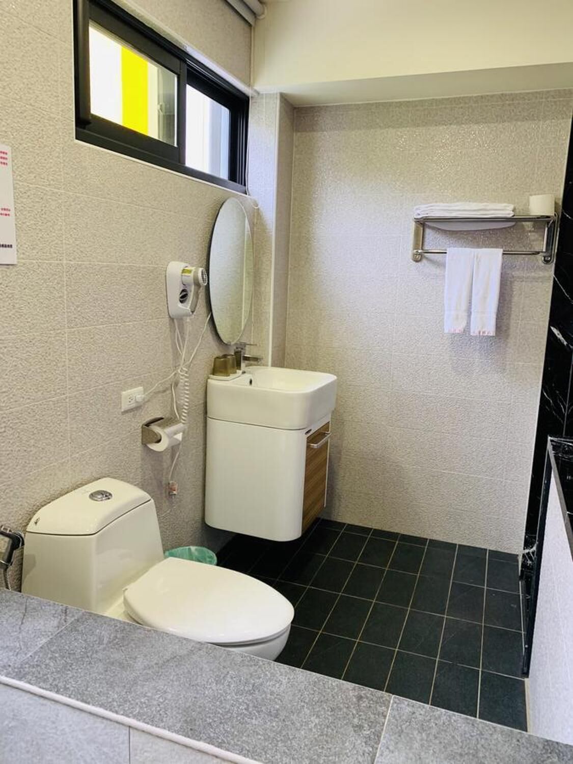 Une petite salle de bain avec des toilettes, un lavabo et un miroir.