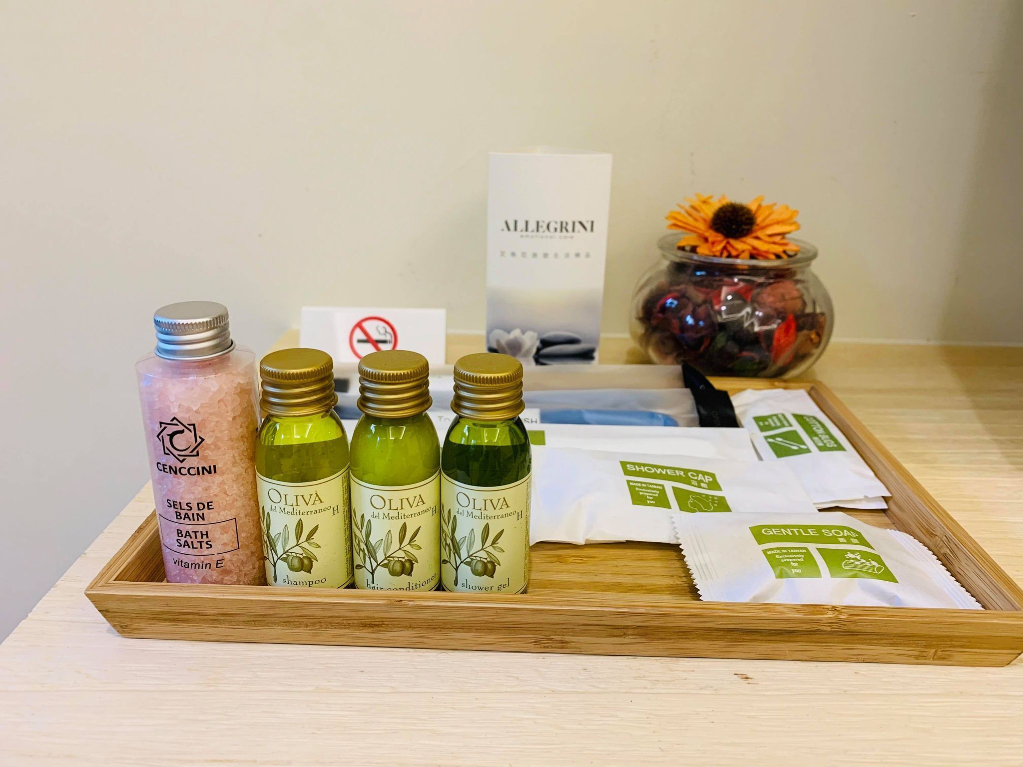 Bandeja de madera con sales de baño, champú, acondicionador para el cabello, gel de ducha y paquetes de gorro de ducha.