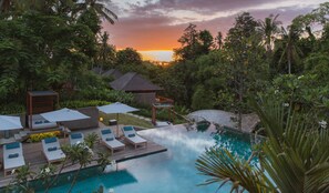 Una piscina al aire libre, camas de piscina gratis, sombrillas