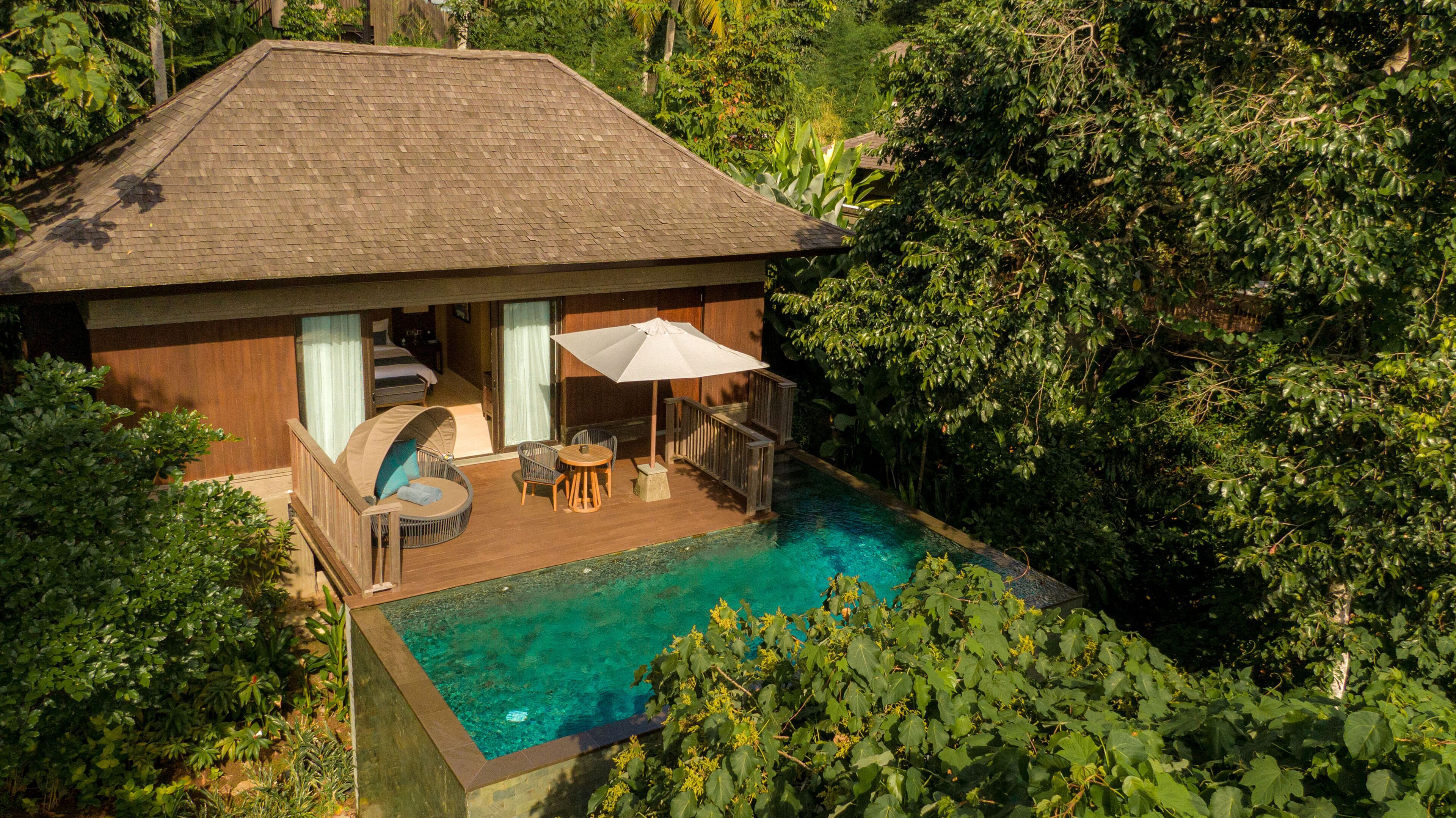 Une maison de plain-pied avec piscine, espace salon extérieur et patio couvert.