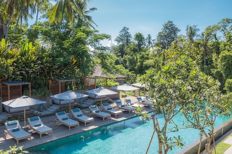 Una piscina al aire libre, camas de piscina gratis, sombrillas
