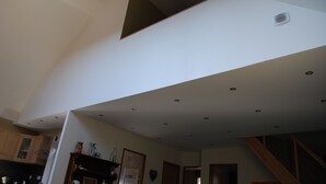 Una cocina moderna con iluminación empotrada, armarios de madera y una escalera visible.