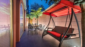 An outdoor patio with a swing chair, a table with chairs, and a red umbrella. - Manxin Hotel Beijing Forbidden City (Beijing)