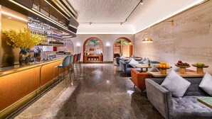 A modern bar area with a polished marble floor, bar stools, and a variety of beverages. There are seating areas with sofas and tables, and a decorative wall with a patterned design. - Manxin Hotel Beijing Forbidden City (Beijing)