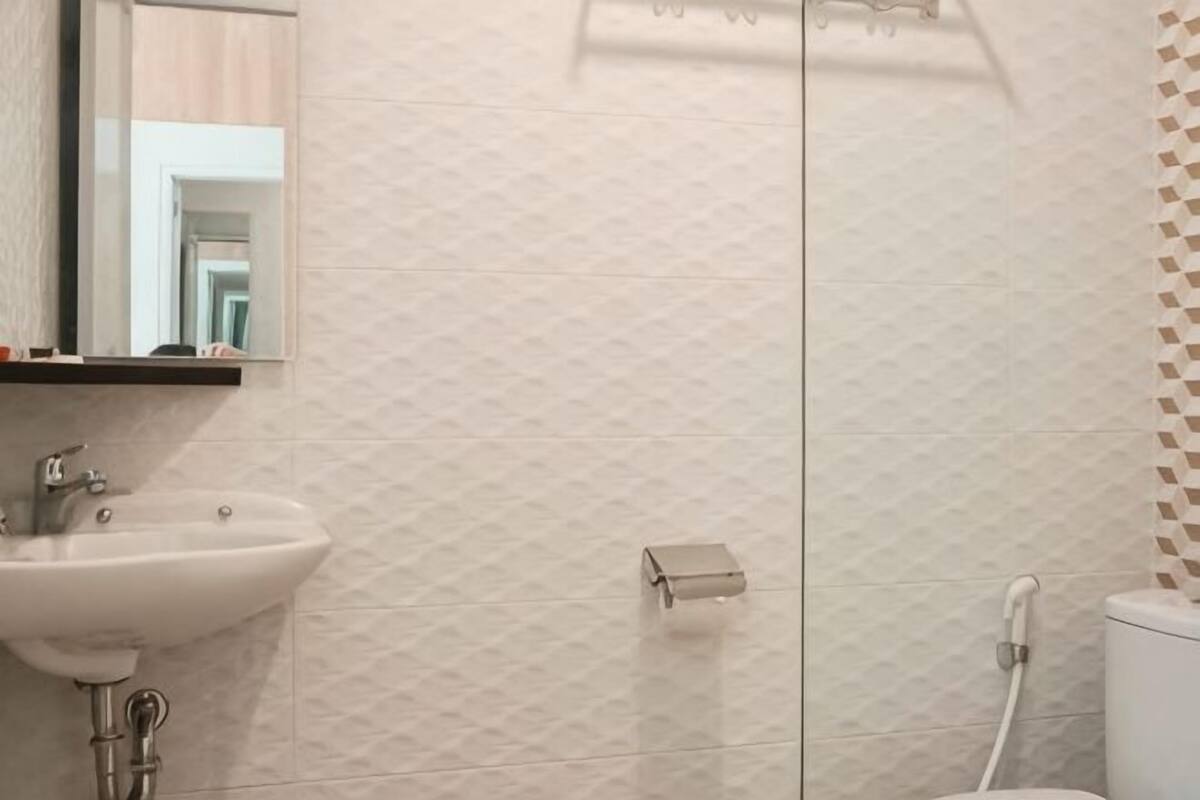 A bathroom with a sink, mirror, and toilet.