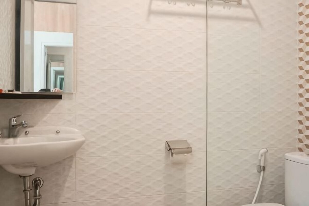 A bathroom with a sink, mirror, and toilet.