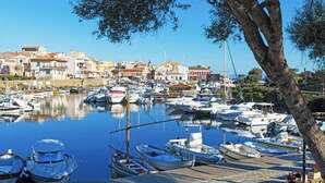 A marina with numerous boats docked, surrounded by buildings with Mediterranean architecture. - Stintino Villa Regina with independent swimming pool, 3 bedrooms, 2 bathrooms (Stintino)