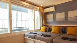 A bedroom with two beds, a large window, and an air conditioning unit. - OYO Myeongdong 5 Lodge (Seoul)