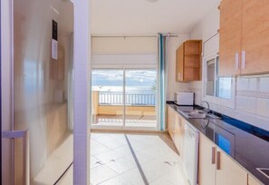 Enjoy a meal with a view of the sea from this kitchen, featuring an oven, sink, and ample counter space.
