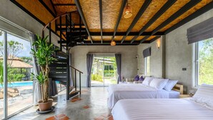 A modern hotel room with two beds, a staircase, a large potted plant, and a view of the outside. - Loftpical Resort (Ko Kaeo)