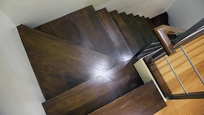 Un escalier avec des marches en bois foncé et une rampe métallique.