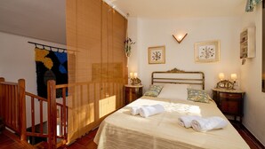 A neatly made bed with towels, a wooden railing, and two bedside tables with lamps. - 1PX 65 - Cozy house for 8 people with communal pool only 800m from the Calella de Palafrugell beach (Calella de Palafrugell)