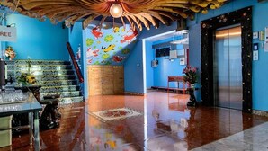 Eine Lobby mit blauer Wand, Holzboden und einer Treppe.