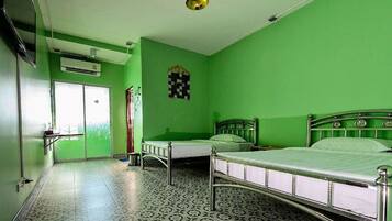 Una habitación con dos camas, un adorno de pared a cuadros y baldosas de suelo estampadas.