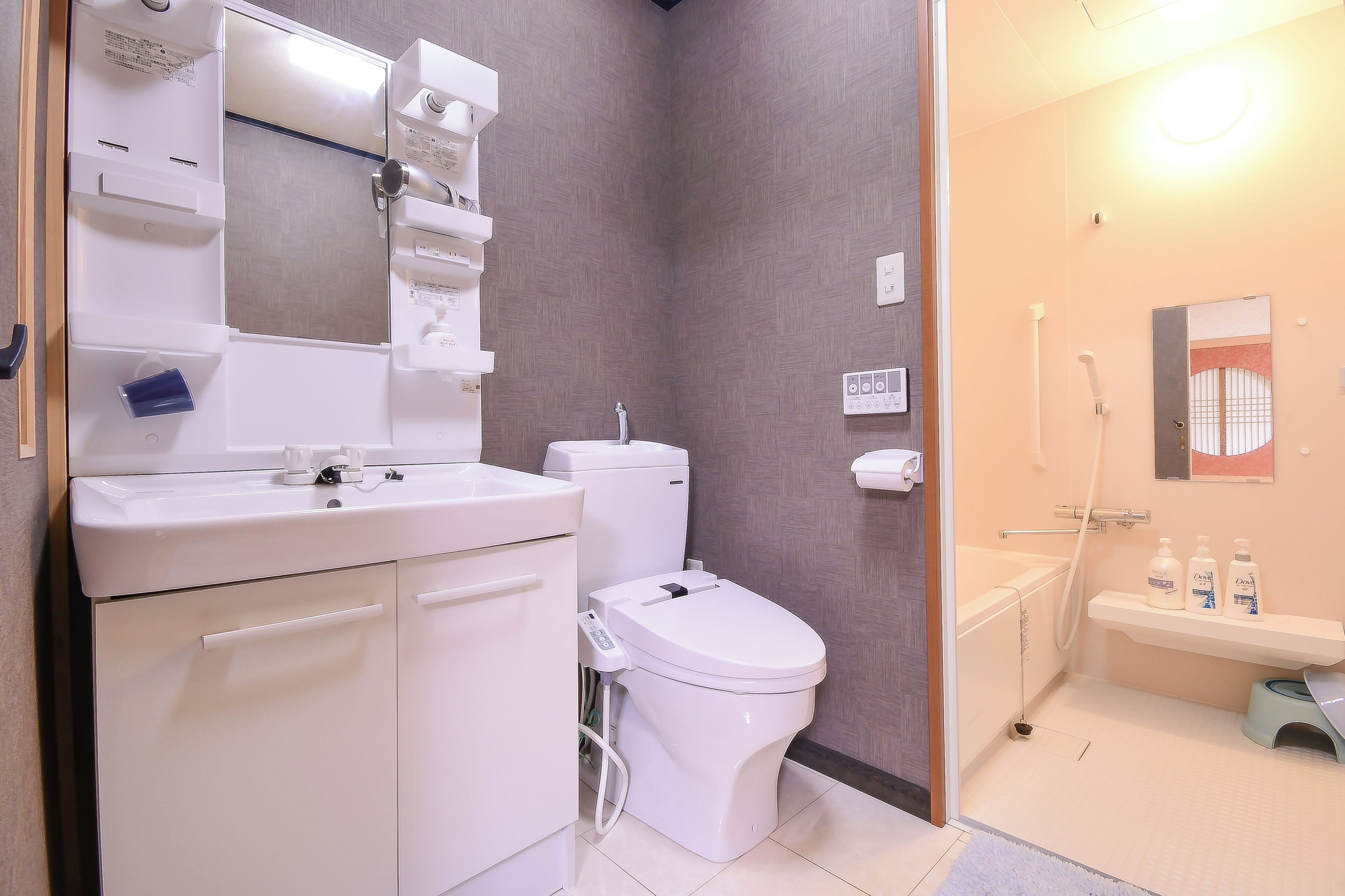 A modern bathroom with a toilet, sink, and shower.