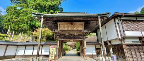 Un torii japonés tradicional con estructura de madera y un letrero.