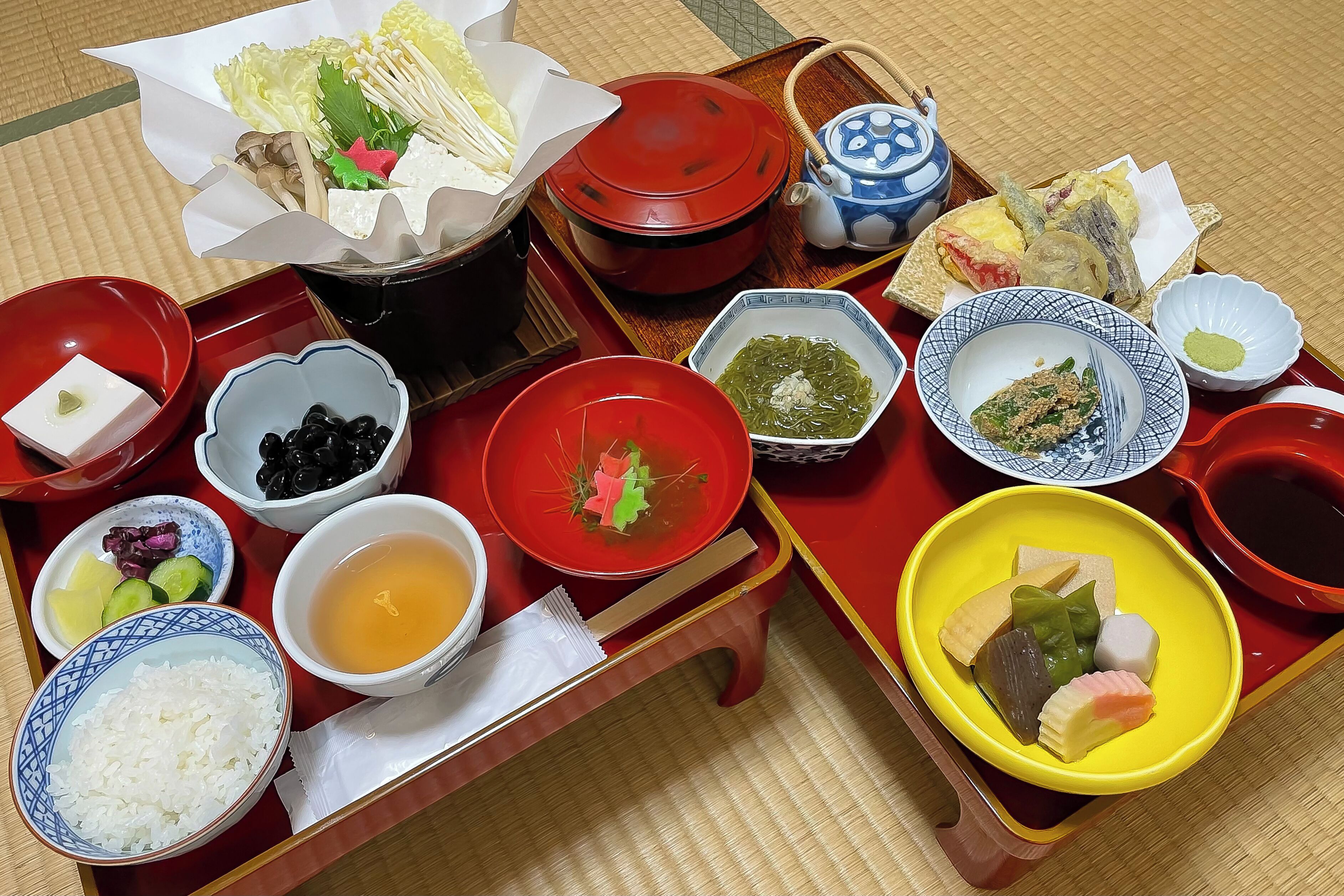 A traditional Japanese meal setup with various dishes and utensils on a wooden tray.