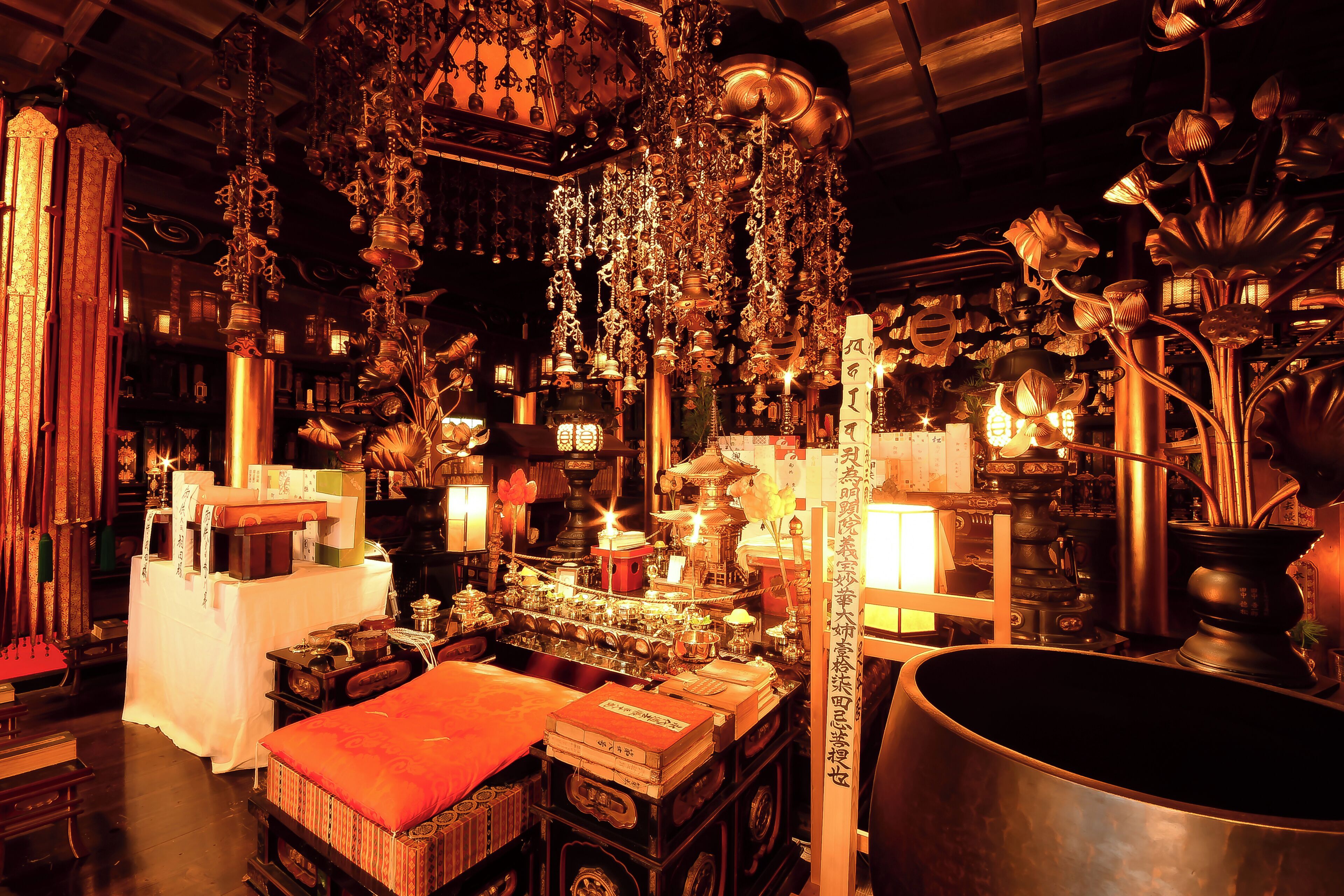 A room with traditional decor, including hanging ornaments and a large metal pot.