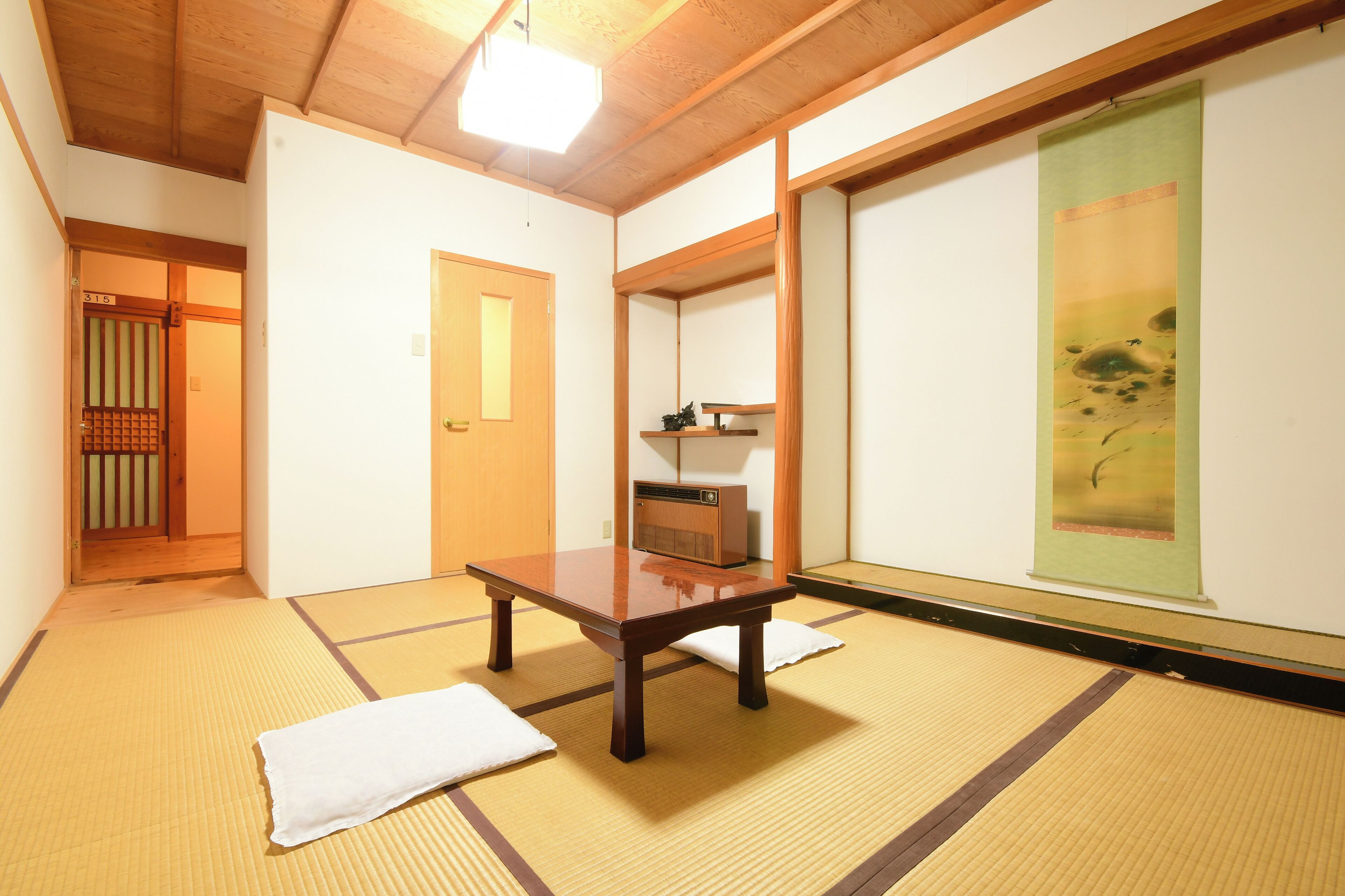A traditional Japanese room with tatami flooring, a low wooden table, and a sliding door.