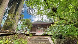 A traditional wooden building with a staircase leading up to a wooden door. - Kongo Sanmaiin (Koya)