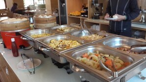 A buffet with various food items including pasta, vegetables, and meats. - Silia Hostel (Ji'an)