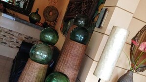 A room with a decorative wall, a mirror, and a vase on a table. - RM Guest House (Dumaguete)