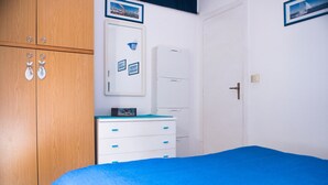 Une chambre à coucher avec un lit, une armoire en bois, une commode blanche et une porte blanche.