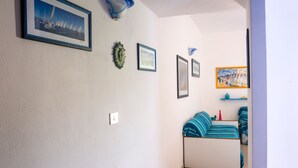 Une pièce avec un lit, un mur orné de tableaux encadrés et un luminaire au plafond.
