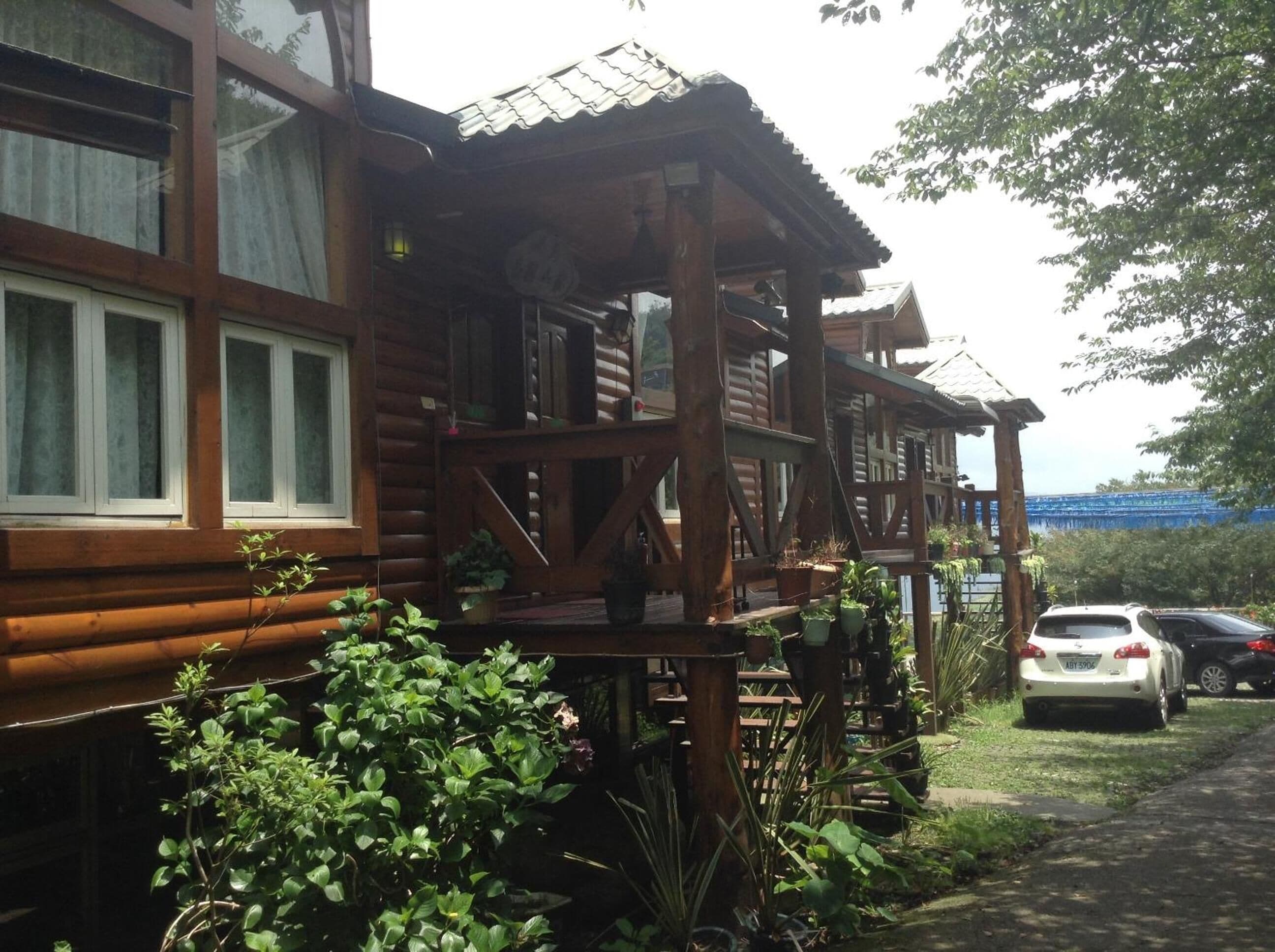 A wooden cabin with a porch and potted plants.