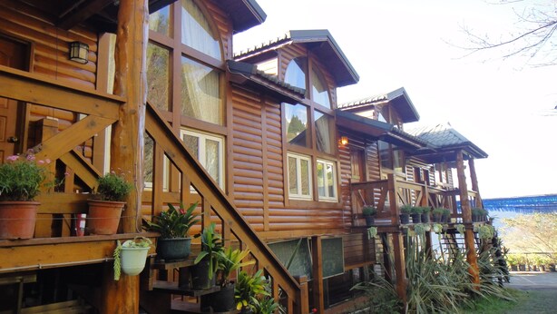 A wooden cabin with a staircase leading to a deck.