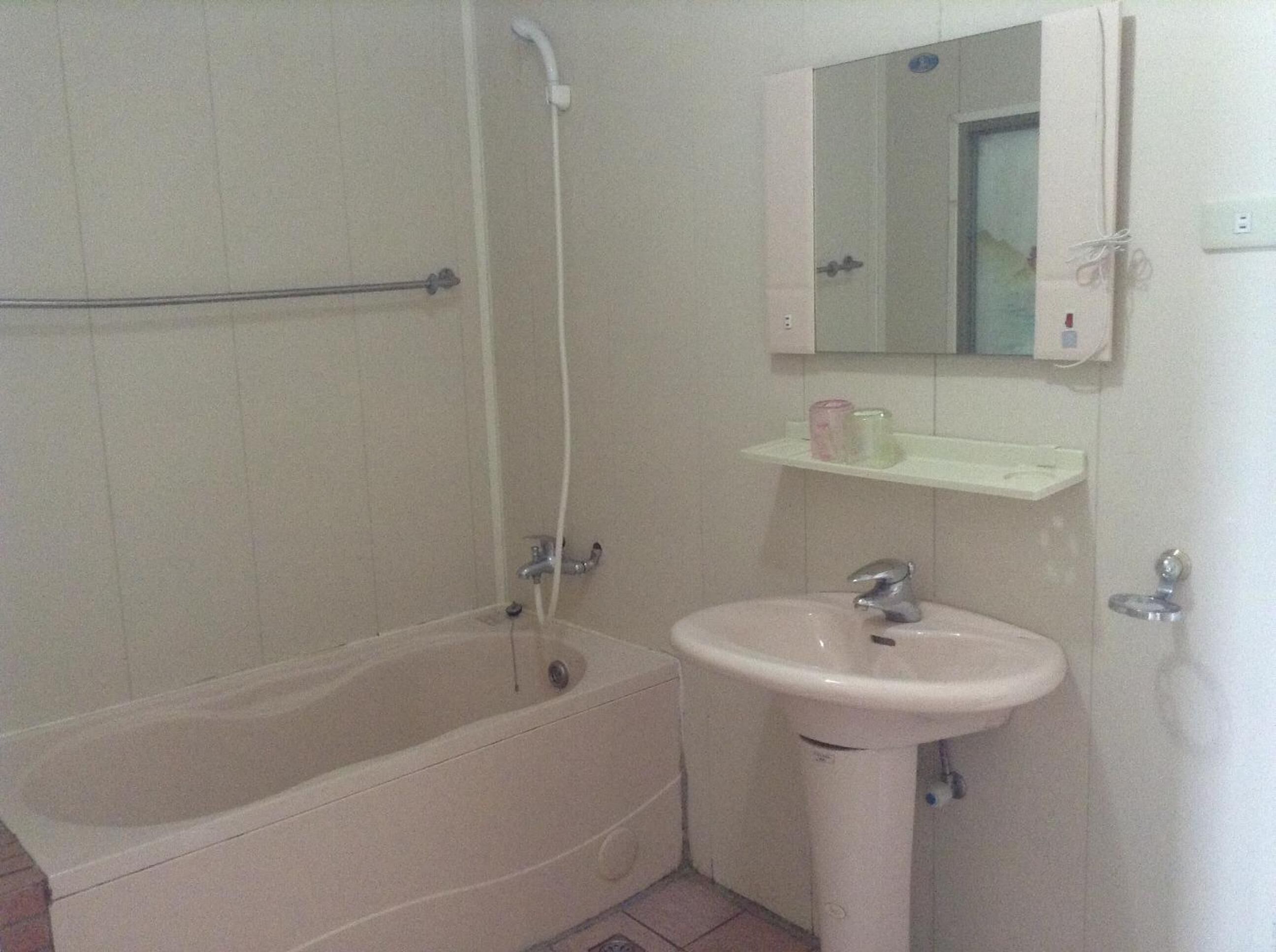 A bathroom with a bathtub, a sink, and a mirror.