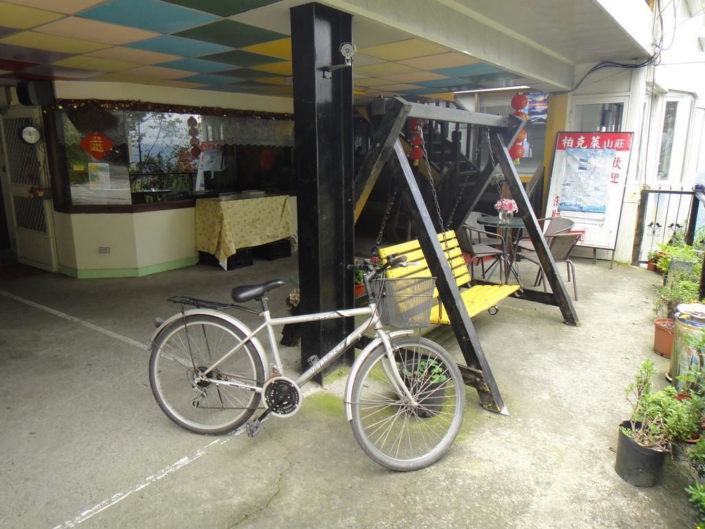 Una bicicleta estacionada frente a un edificio con un columpio amarillo y negro.
