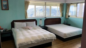 A hotel room with two beds, wooden headboards, a nightstand with a lamp, and a window with curtains. - Bokelai B&B (Ren'ai)