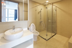 A modern bathroom with a glass-enclosed shower, a white sink, and a toilet. - Celine Home - Vinhomes Central Park (Ho Chi Minh City)