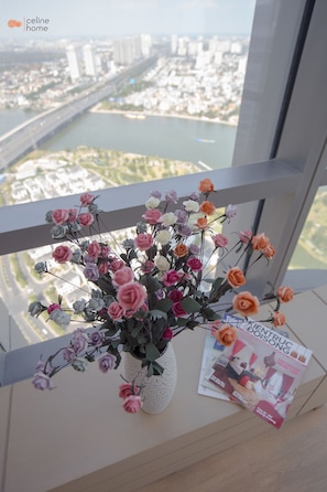 A balcony with a vase of flowers and a magazine. - Celine Home - Vinhomes Central Park (Ho Chi Minh City)