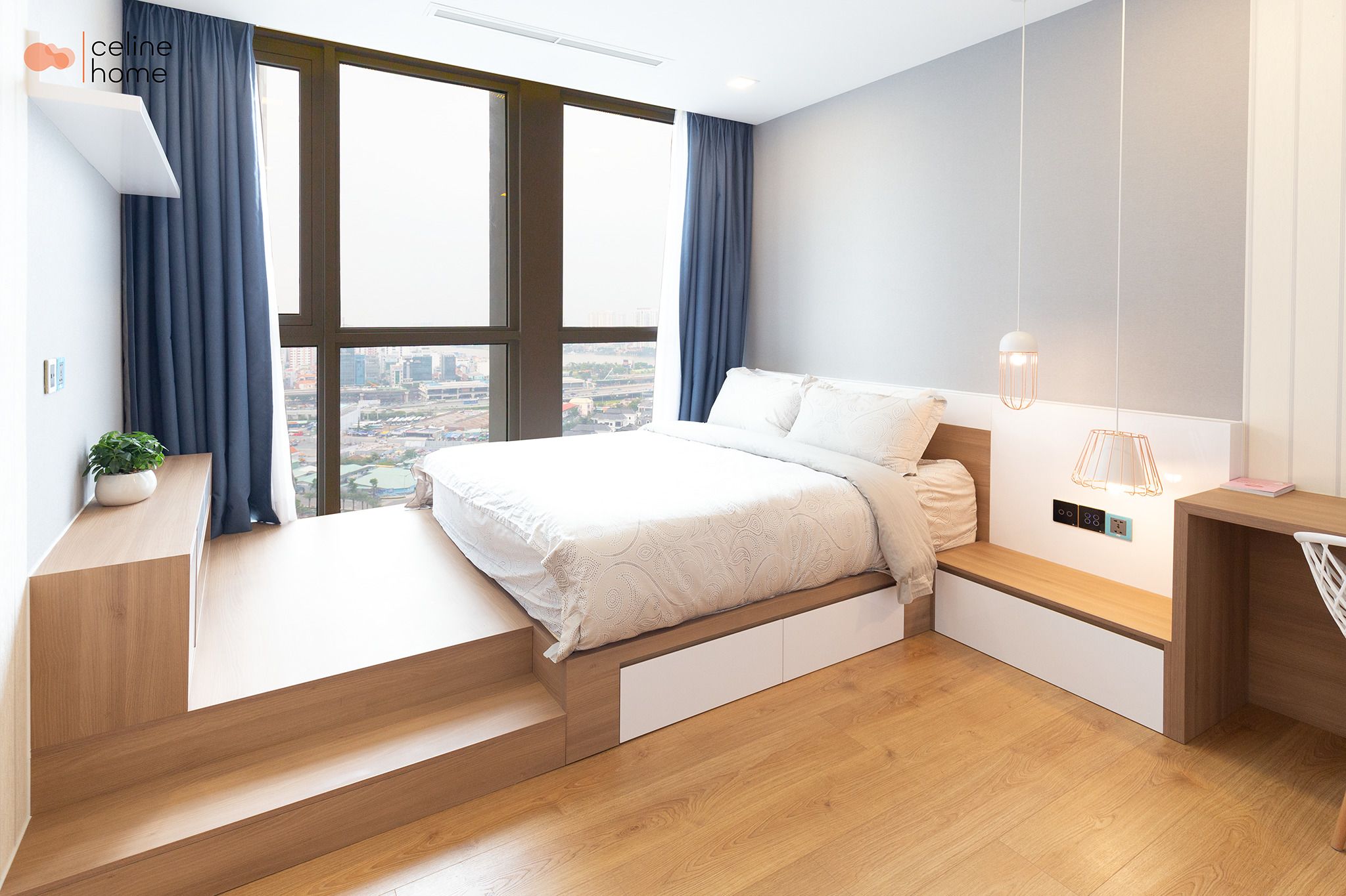 Ein modernes Schlafzimmer mit Bett, Einbauschränken, Schreibtisch und Blick auf die Stadt.