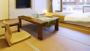 A hotel room with a bed, a TV, a table, and a chair. - Yuyuan (Kirishima)